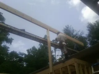Carpenter setting a ridge beam over a new addition frame — Ice Dam Removal by Roofing Brothers in Montgomery Creek