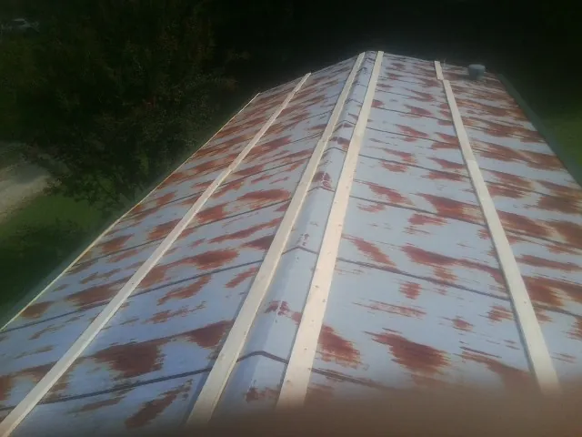 Rusted metal roof panels with new wood purlins before replacement — Storm Damage Roof Repair in Montgomery Creek by Roofing Brothers