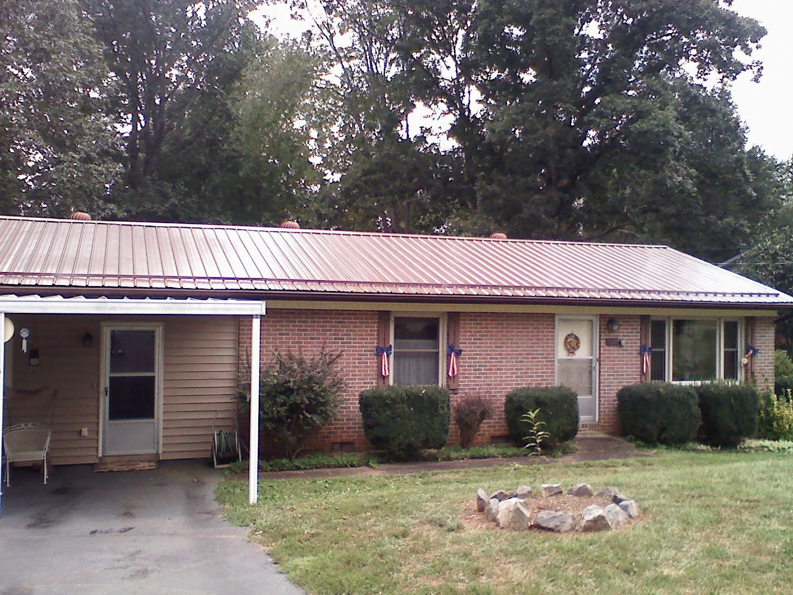 Bronze metal roof and carport on a brick ranch home — Roof Repair work by our crew in Montgomery Creek