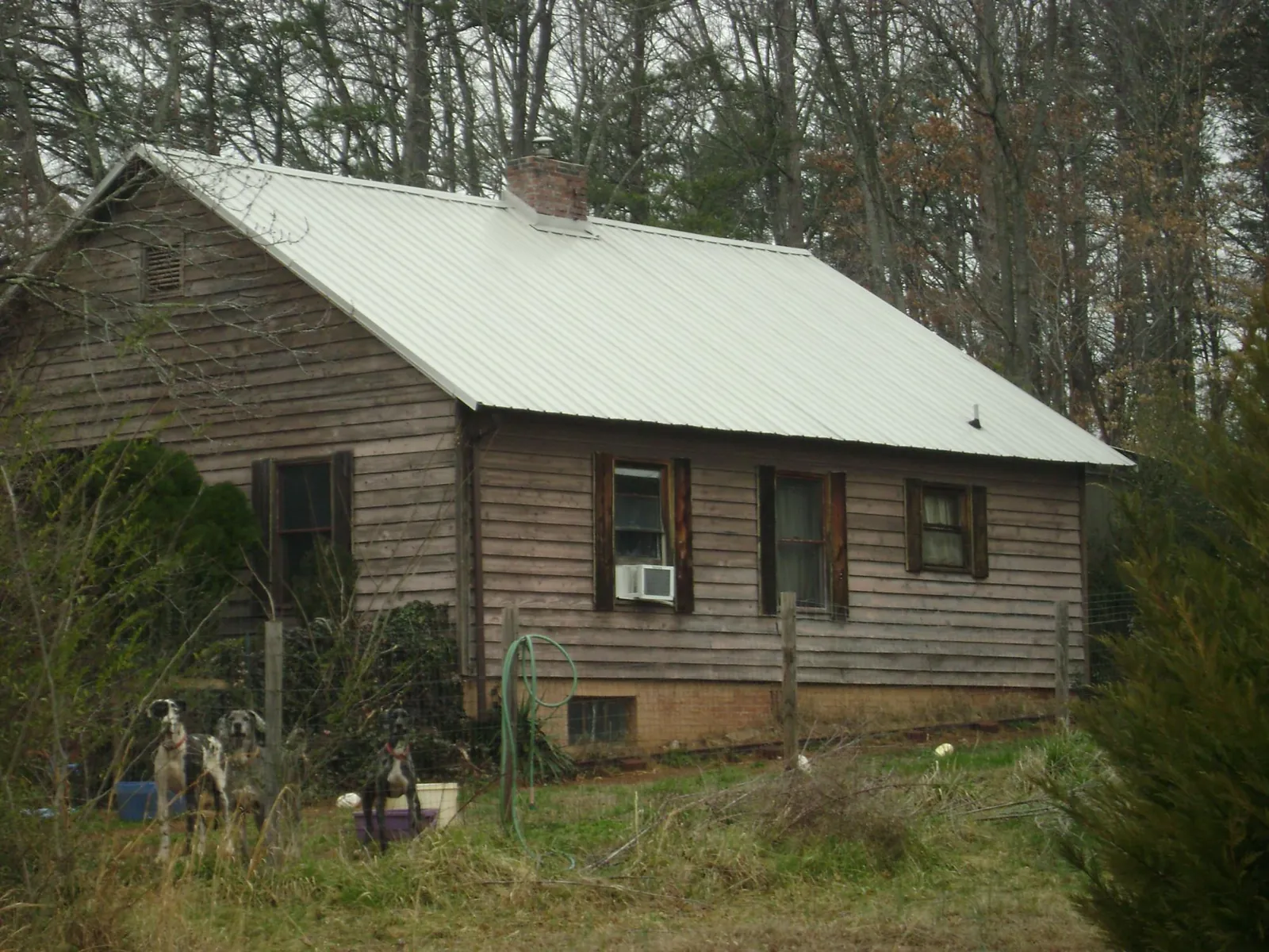 White metal roof on an old wood sided farmhouse, from a Metal Roof Installation job in Montgomery Creek